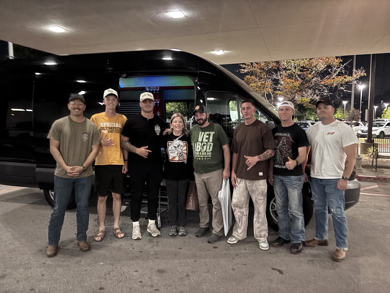 TPL guests gathered beside a black Sprinter for their group transportation